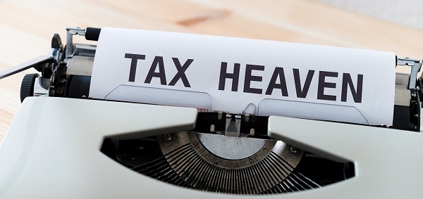 'TAX HEAVEN'이라는 글자가 타자기에 꽂혀 있는 이미지 